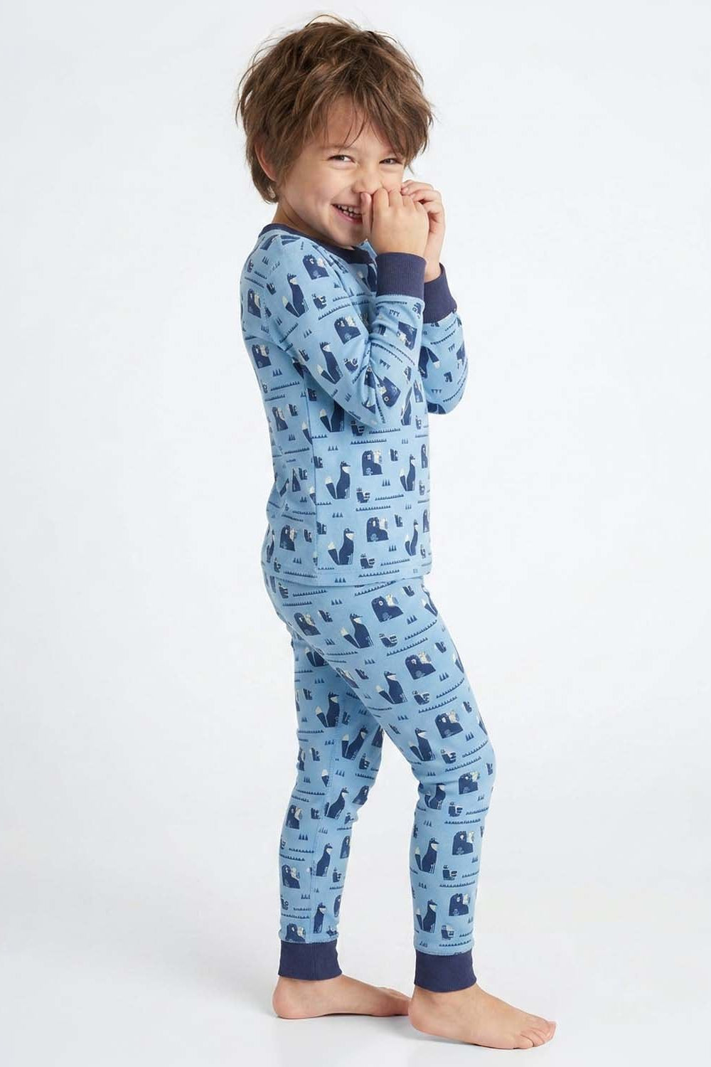 Child wearing blue pajamas with a pattern on a white background