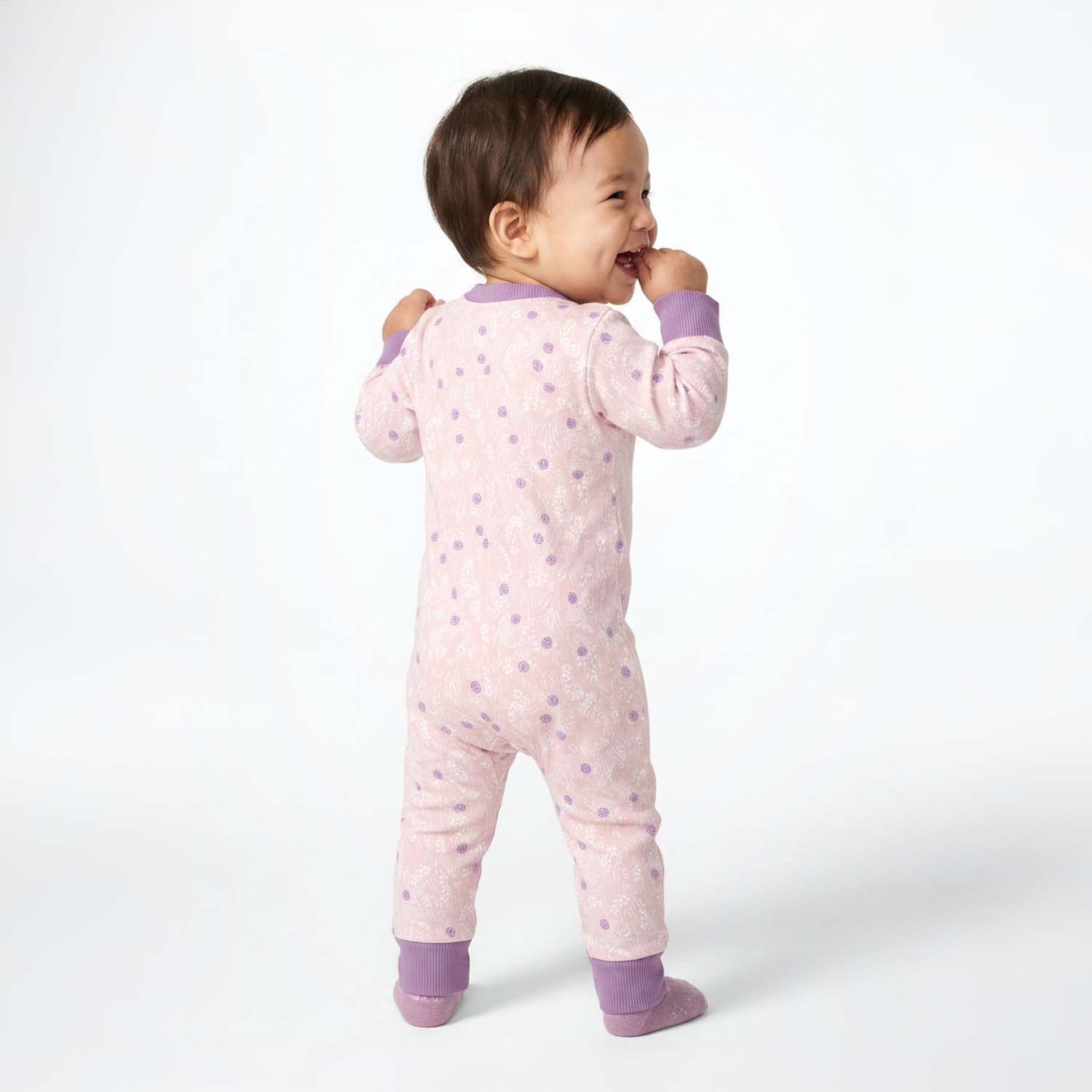 Baby wearing a pink onesie with purple accents on a white background