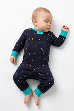 Baby wearing a dark blue onesie with colorful patterns on a white background