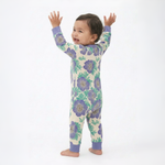 Baby wearing a floral onesie with arms raised on a white background