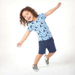 Child wearing a blue patterned shirt and navy shorts on a white background
