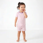 Child wearing pink pajamas with a white background