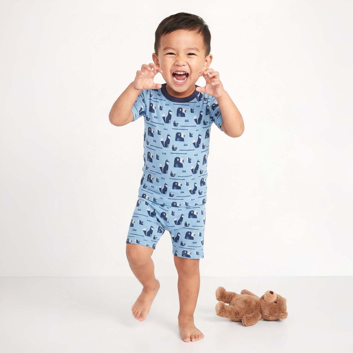 Child wearing a blue pajama set with animal pattern on a white background