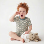 Child in pajamas with a teddy bear on a white background