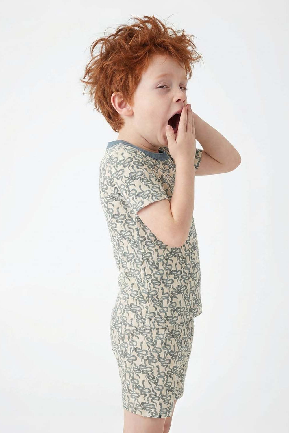 Child wearing a snake print pajamas on a white background