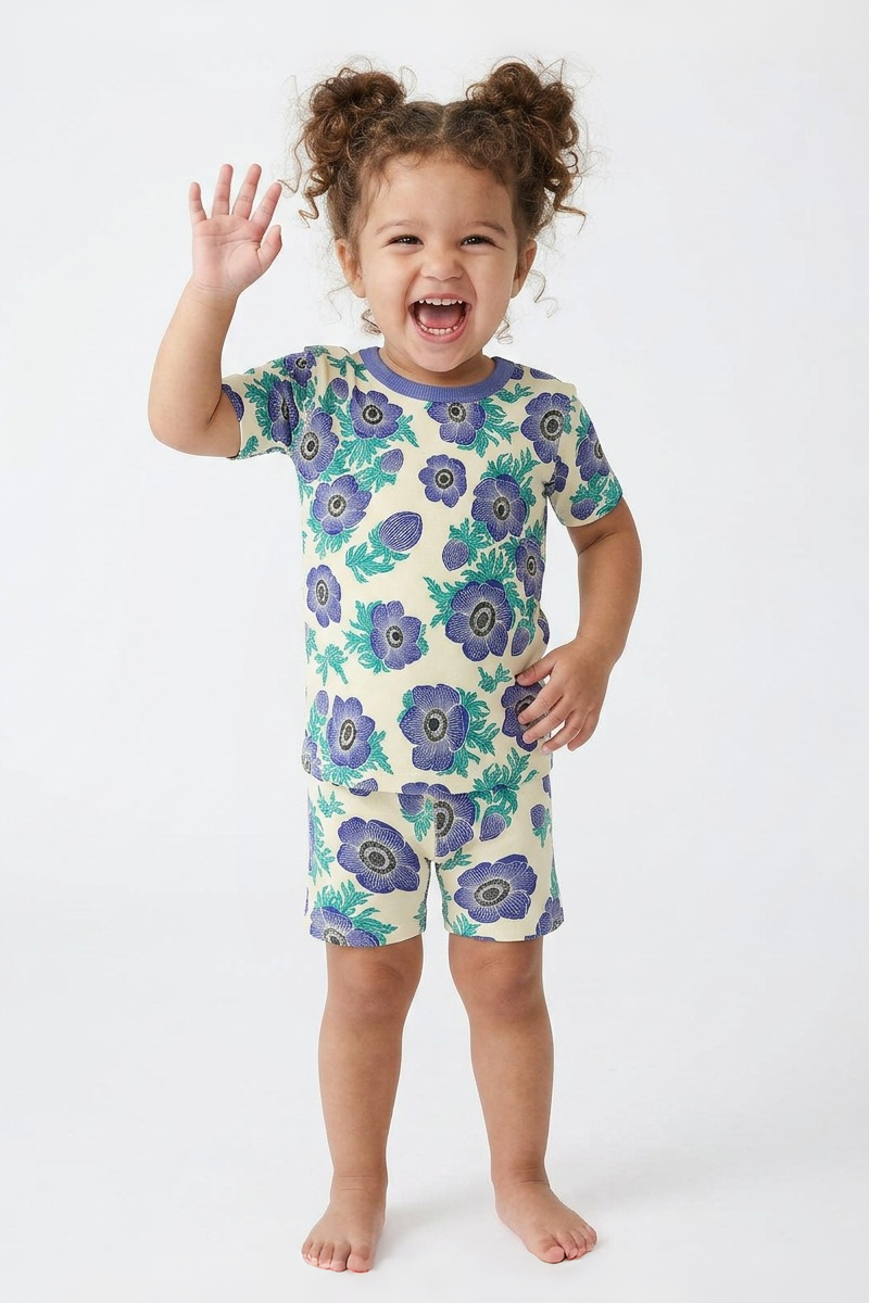 Child wearing a purple floral pajama set on a white background