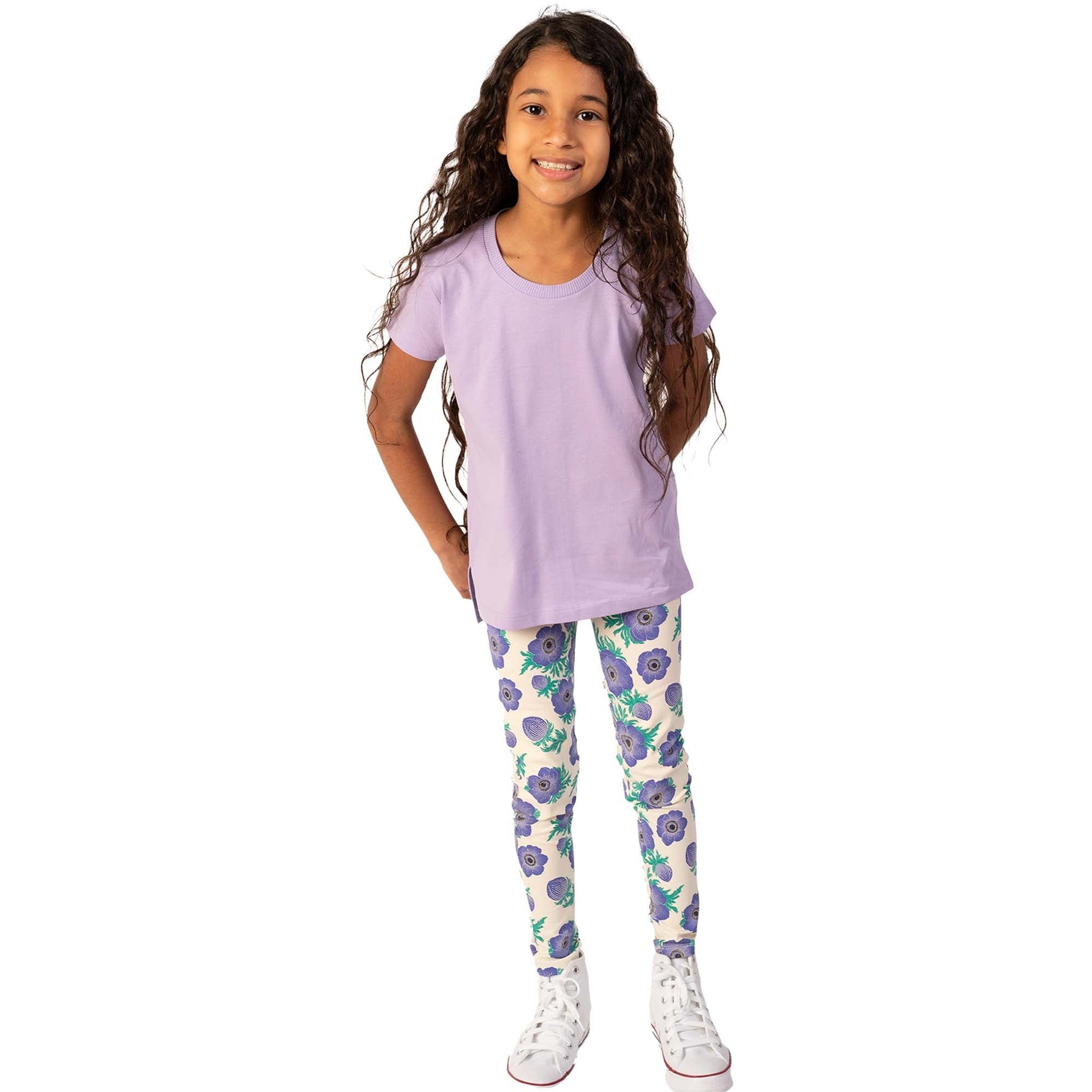 girl with long hair wearing a lavender tee shirt and purple floral leggings