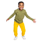 a young boy wearing a olive green long sleeve tee and yellow sweatpants