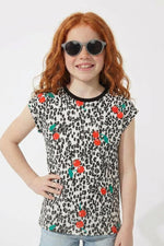 Young girl wearing a leopard print t-shirt with colorful flower patterns on a white background