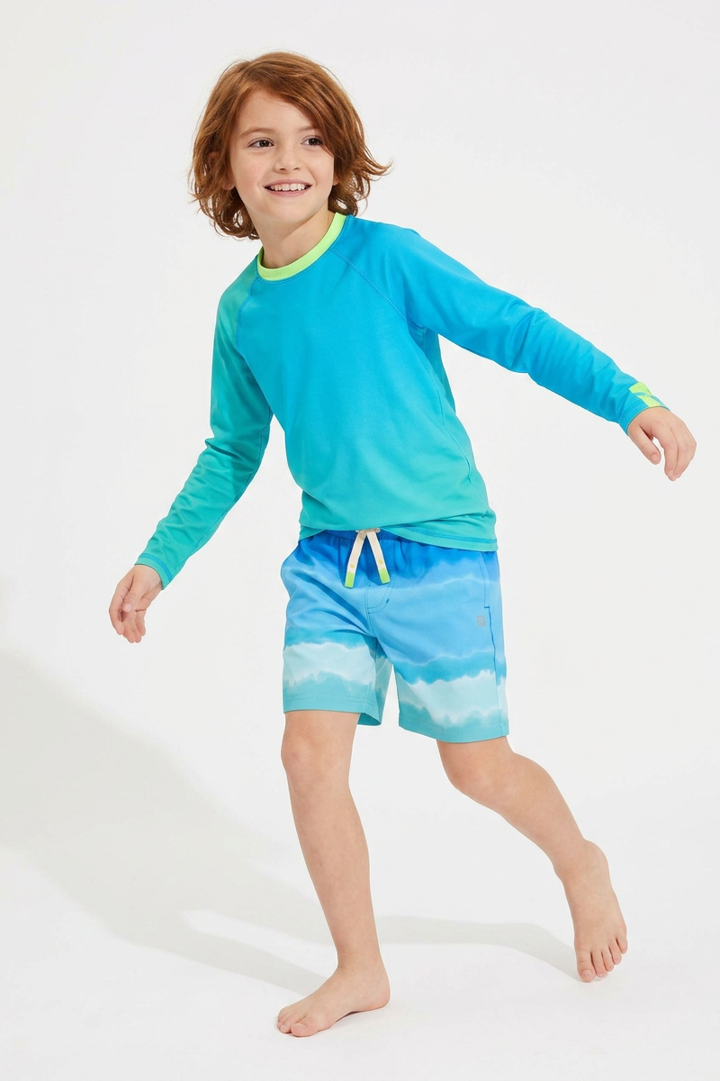 Child wearing a blue long-sleeve rash guard and matching shorts on a white background